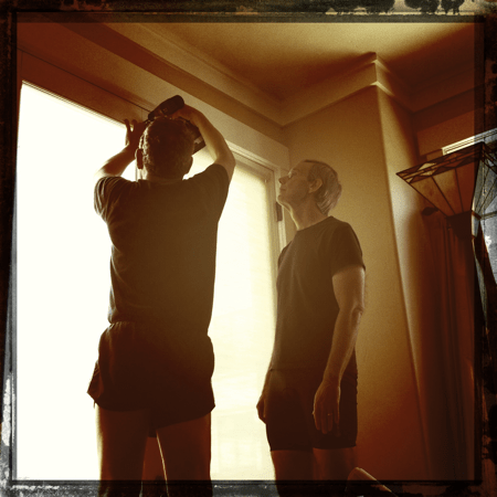 Buck watches as Steve shows him how to hang&nbsp;blinds